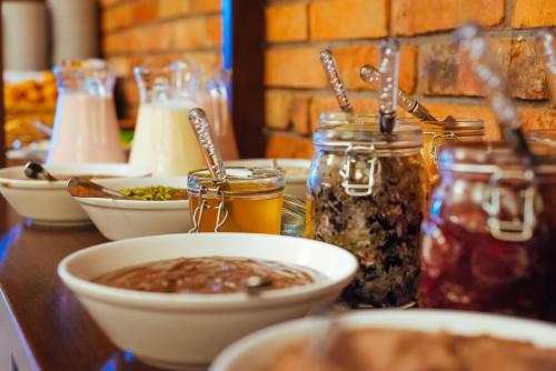 a table topped with bowls and jars of food at Mikołajki Resort Hotel & Spa Jora Wielka in Mikołajki
