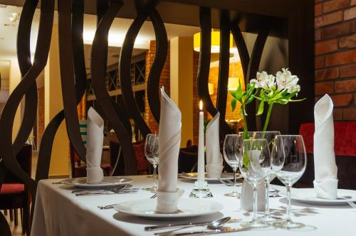 a table with white napkins and wine glasses on it at Mikołajki Resort Hotel & Spa Jora Wielka in Mikołajki