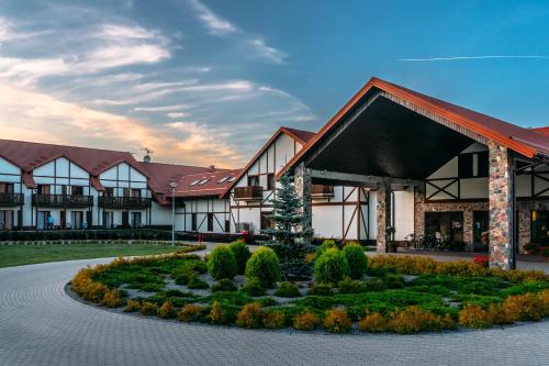 budynek z ogrodem przed nim w obiekcie Mikołajki Resort Hotel & Spa Jora Wielka w mieście Mikołajki