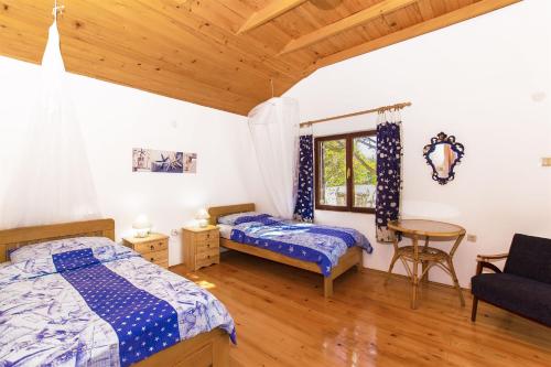a bedroom with two beds and a table at House Silvestra in Borovići