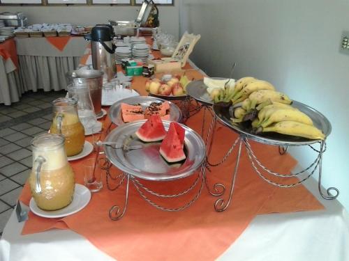 a table topped with plates of food and drinks at Oft Plaza Oeste Hotel in Goiânia