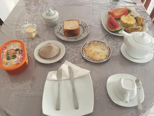 a table with plates of food and utensils on it at Bentota Home Stay in Bentota
