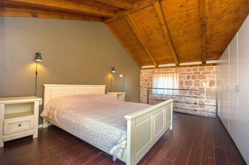 ein Schlafzimmer mit einem Bett und einer Ziegelwand in der Unterkunft House Stone house island Prvic in Prvić Šepurine