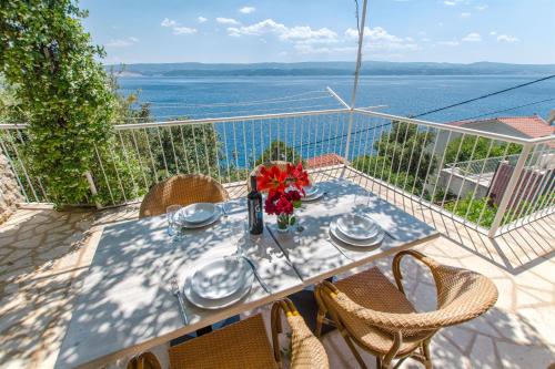 a table on a balcony with a view of the water at Apartments Vedran in Čelina