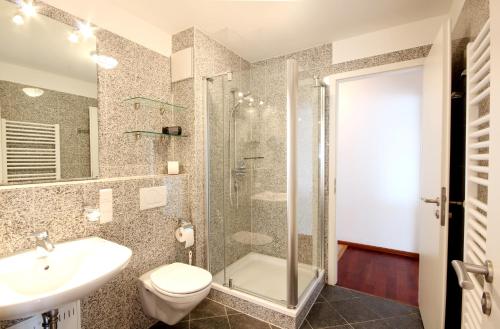 ein Bad mit einer Dusche, einem WC und einem Waschbecken in der Unterkunft Villa Helene by Rujana in Binz
