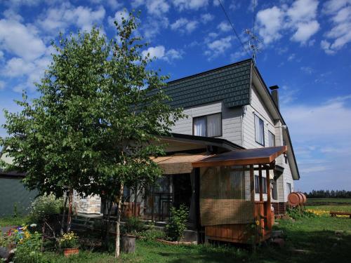 a house with a tree in front of it at Akane-yado in Nakafurano