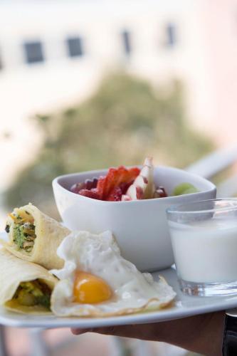 a plate of food with an egg and a bowl of food at Community Hostel Alausi in Alausí