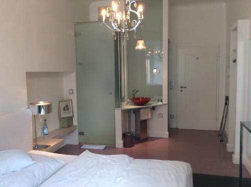 a bedroom with a bed and a sink and a mirror at Hotel Heidelberg Astoria in Heidelberg