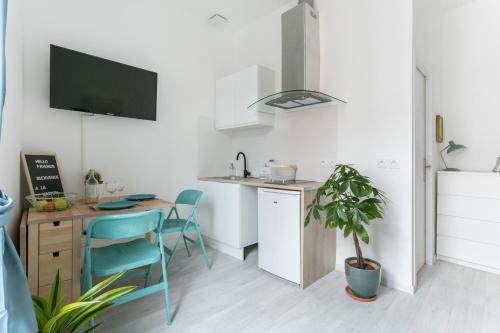 een keuken met een bureau en een tafel met stoelen bij Studio proche Jean Moulin, location courte durée in Béziers