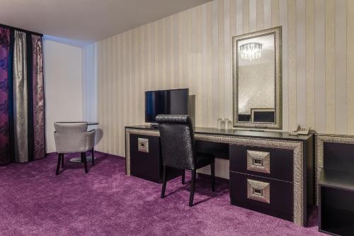 a hotel room with a desk and a television at Hotel Elegance in Stara Zagora