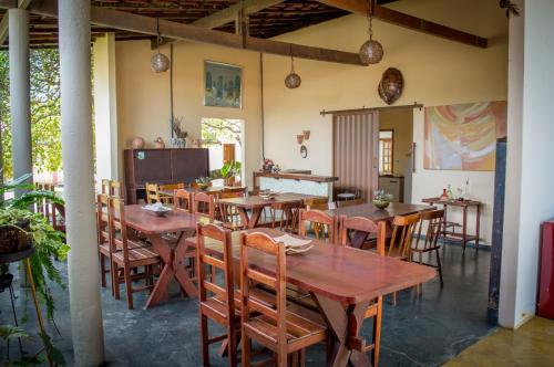 uma sala de jantar com mesas e cadeiras de madeira em Pousada Do Caju em Nova Viçosa