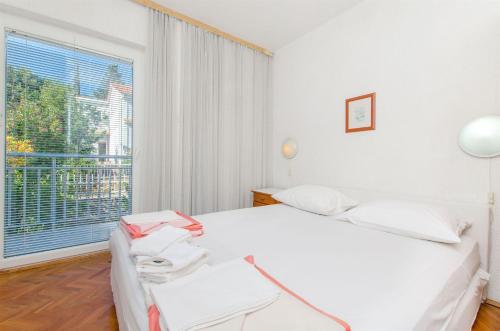 una camera bianca con un letto e una grande finestra di Apartments Osvit a Stari Grad (Cittavecchia)