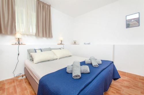 a bedroom with a bed with towels on it at Apartments and Rooms Anita in Vrboska