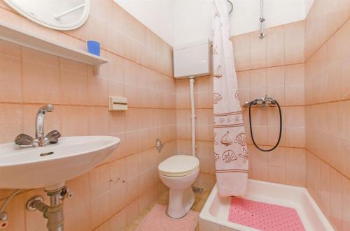 une salle de bains avec lavabo, toilettes et douche dans l'établissement Apartments Bozjidar, à Stari Grad