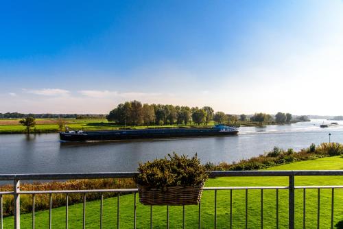 a large barge traveling down a river at Vakantie aan de Maas in Broekhuizen