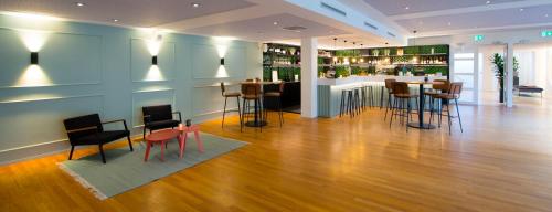 a room with a bar with stools and a table at Leerhotel Het Klooster in Amersfoort