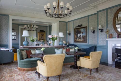 a living room with a couch and a table and chairs at Four Seasons Hotel Hampshire in Winchfield