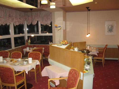 a dining room with tables and chairs in a restaurant at Hotel Restaurant Escher in Leukerbad