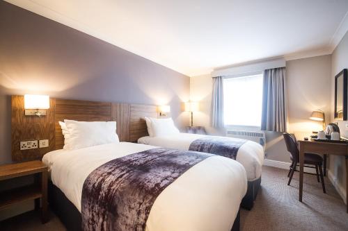 a hotel room with two beds and a desk at Toby Carvery Old Windsor by Innkeeper's Collection in Windsor