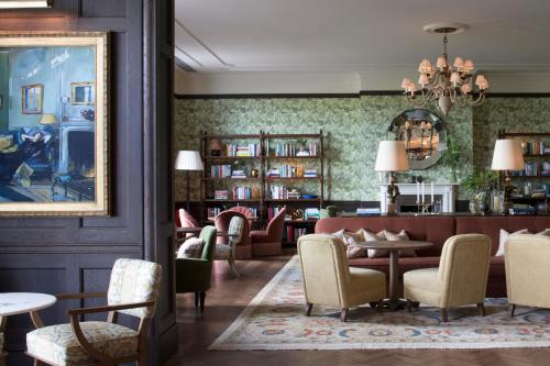 a lobby with a library with chairs and a table at Four Seasons Hotel Hampshire in Winchfield