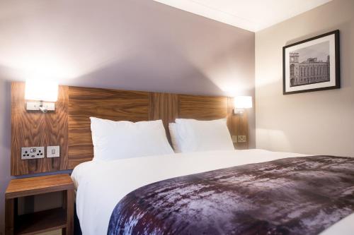 a hotel room with a large bed with white sheets at Toby Carvery Old Windsor by Innkeeper's Collection in Windsor