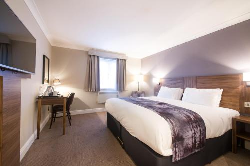 a hotel room with a large bed and a desk at Toby Carvery Old Windsor by Innkeeper's Collection in Windsor