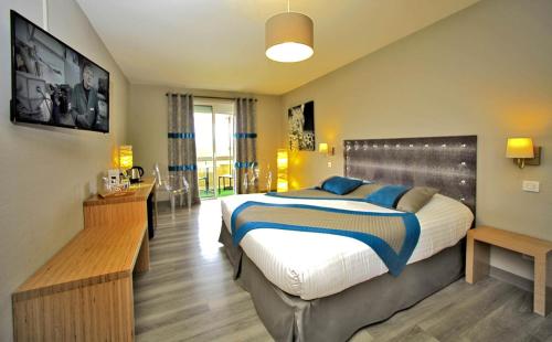 a bedroom with a large bed with blue pillows at Hotel Restaurant Laborderie in Tamniès