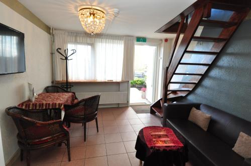 a living room with a staircase and a table at Pension & Spa de Watertoren in Zandvoort