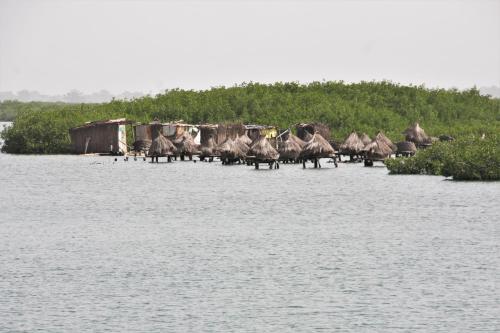 a group of huts on a beach next to the water at Africa 6 Plage in Somone