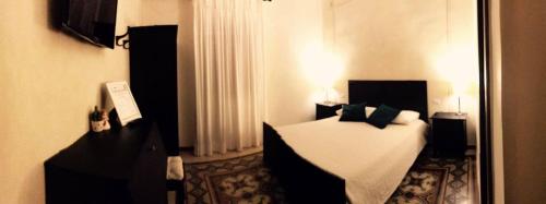 バーリにあるLes Fleurs b&bのベッドと鏡が備わるホテルルーム