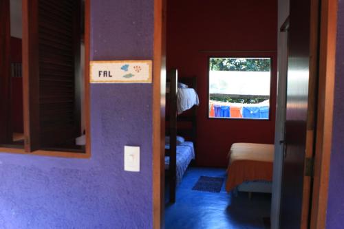 a room with a room with a bed and a window at Pousada O Canto das Sereias in Trindade