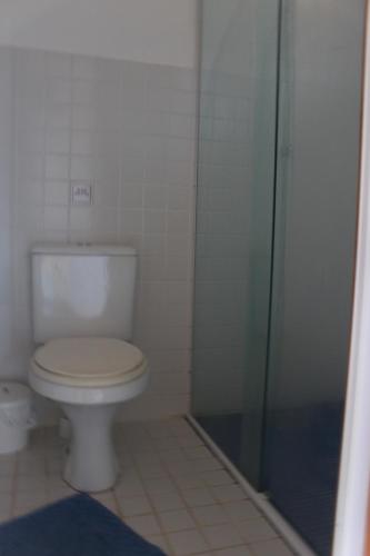 a bathroom with a toilet and a glass shower at Pousada O Canto das Sereias in Trindade