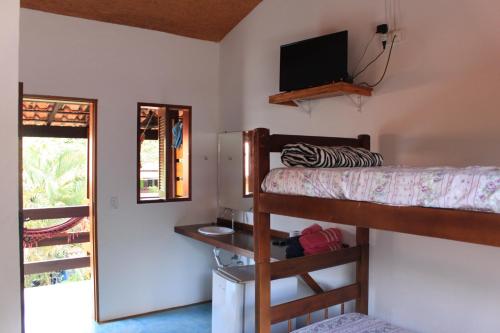 a room with two bunk beds and a television at Pousada O Canto das Sereias in Trindade