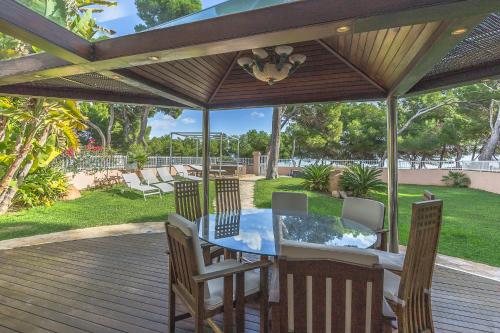 eine Terrasse mit einem Tisch und Stühlen auf einer Terrasse in der Unterkunft YupiHome Villa Ran de Mar in Port d'Alcúdia