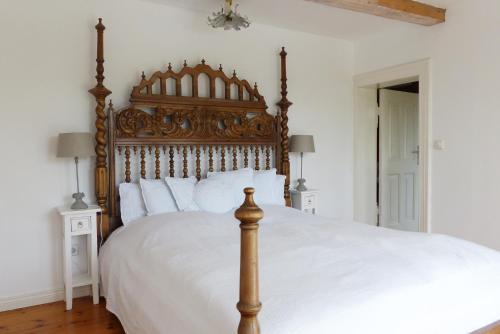 a bedroom with a large bed with a wooden headboard at Villa am Trumpf - Design-Appartements im Naturgarten am See in Melzow