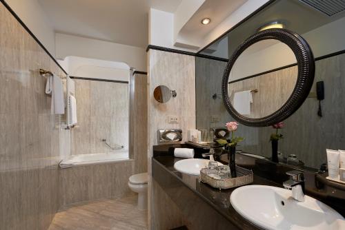 une salle de bain avec un lavabo et un miroir et des toilettes dans l'établissement Meliá Paris Vendôme, à Paris
