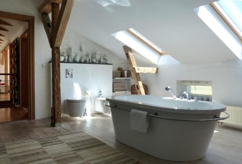 ein Badezimmer mit einer großen Badewanne im Dachgeschoss in der Unterkunft Villa am Trumpf - Design-Appartements im Naturgarten am See in Melzow