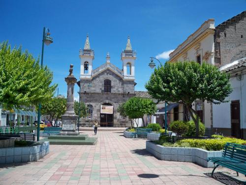 a large building with two towers on a city street at Las Garzas Alojamiento in Ibarra