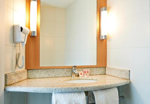 a bathroom counter with a sink and a mirror at ibis Rio de Janeiro Parque Olimpico in Rio de Janeiro