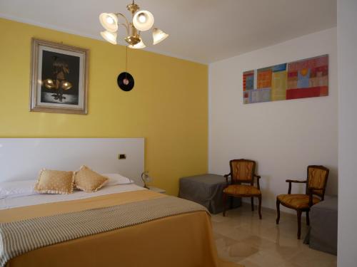 sypialnia z łóżkiem i 2 krzesłami w obiekcie Donna Nicla B&B w mieście Matera