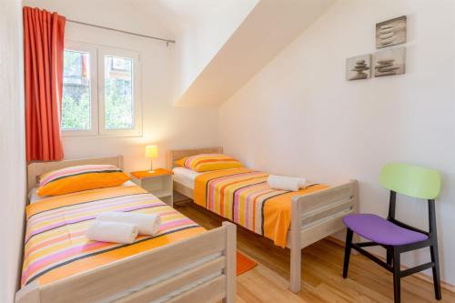 a bedroom with two beds and a chair in it at Apartment Ante in Milna