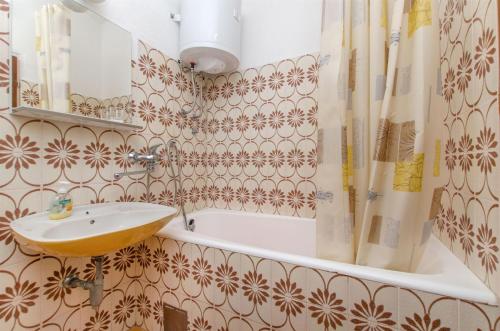 ein Badezimmer mit einem Waschbecken und einer Badewanne in der Unterkunft Apartments Jerka in Sutivan