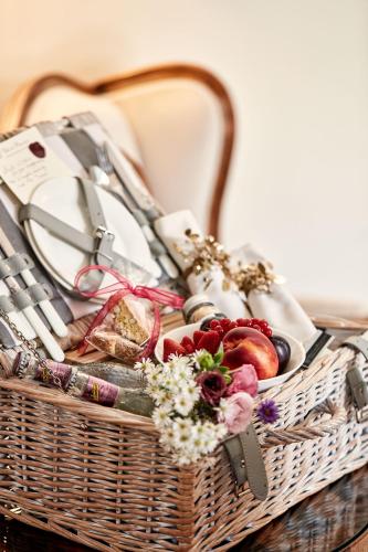 a basket filled with food and flowers on a table at Villa di Piazzano - Small Luxury Hotels of the World in Cortona
