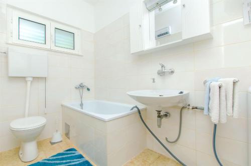 a white bathroom with a sink and a toilet at Apartment Ida in Brna