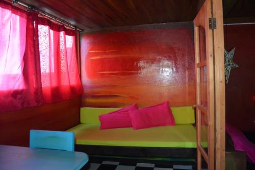 a small room with a couch with pink and green pillows at Black Mamba in Paul