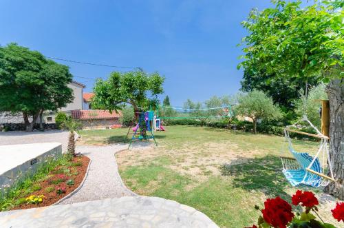 a yard with two chairs and a playground at House Poljica with a pool in Poljica