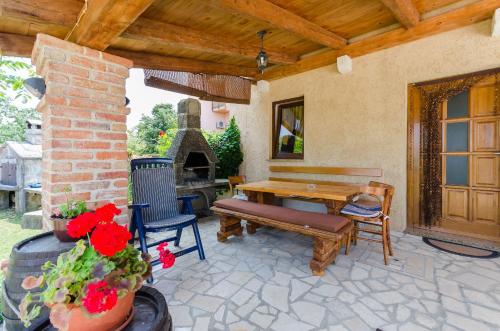 a patio with a bench and a table and a fireplace at House Poljica with a pool in Poljica