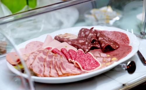 a plate of food with meat and chocolate on a table at Hotel am Katharinenholz in Potsdam