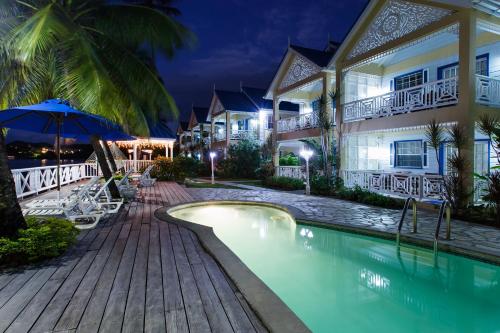 a resort with a swimming pool at night at Villa Beach Cottages in Castries