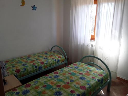 a bedroom with two beds and a window at Sardinia Beach Apartments in Aglientu